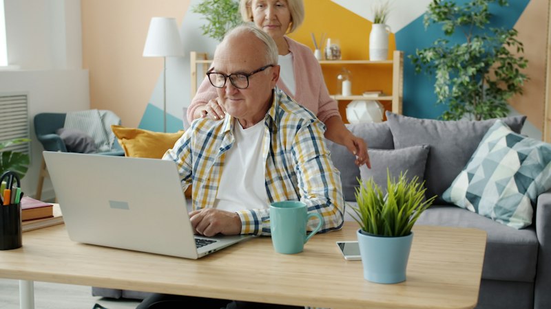 An older couple using a laptop at home
